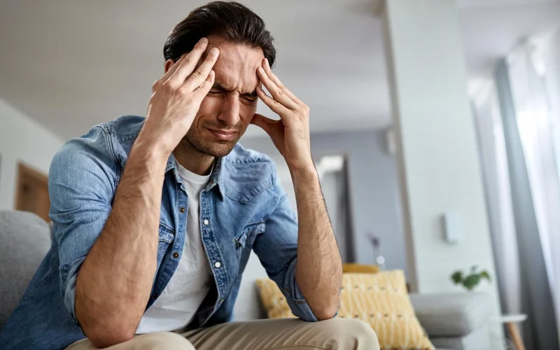 low-angle-view-distraught-man-holding-his-head-pain